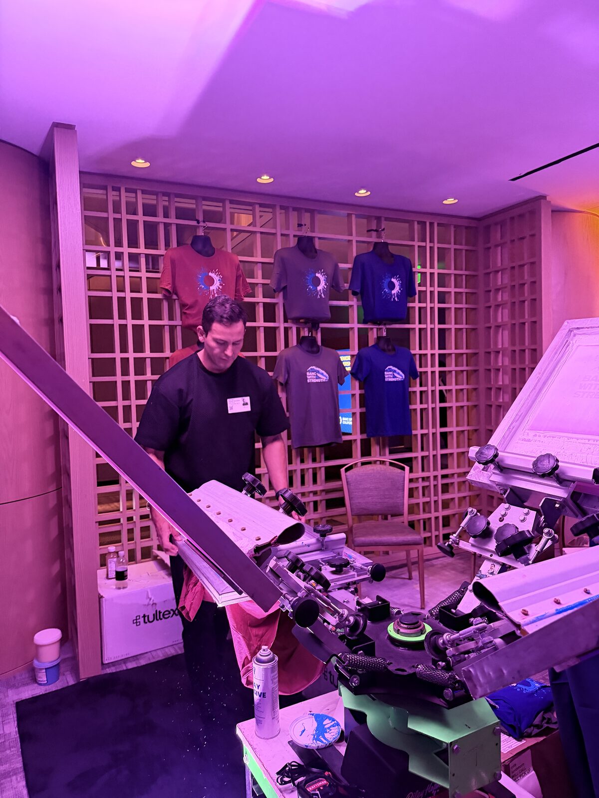 Operator loading a shirt onto a screen press